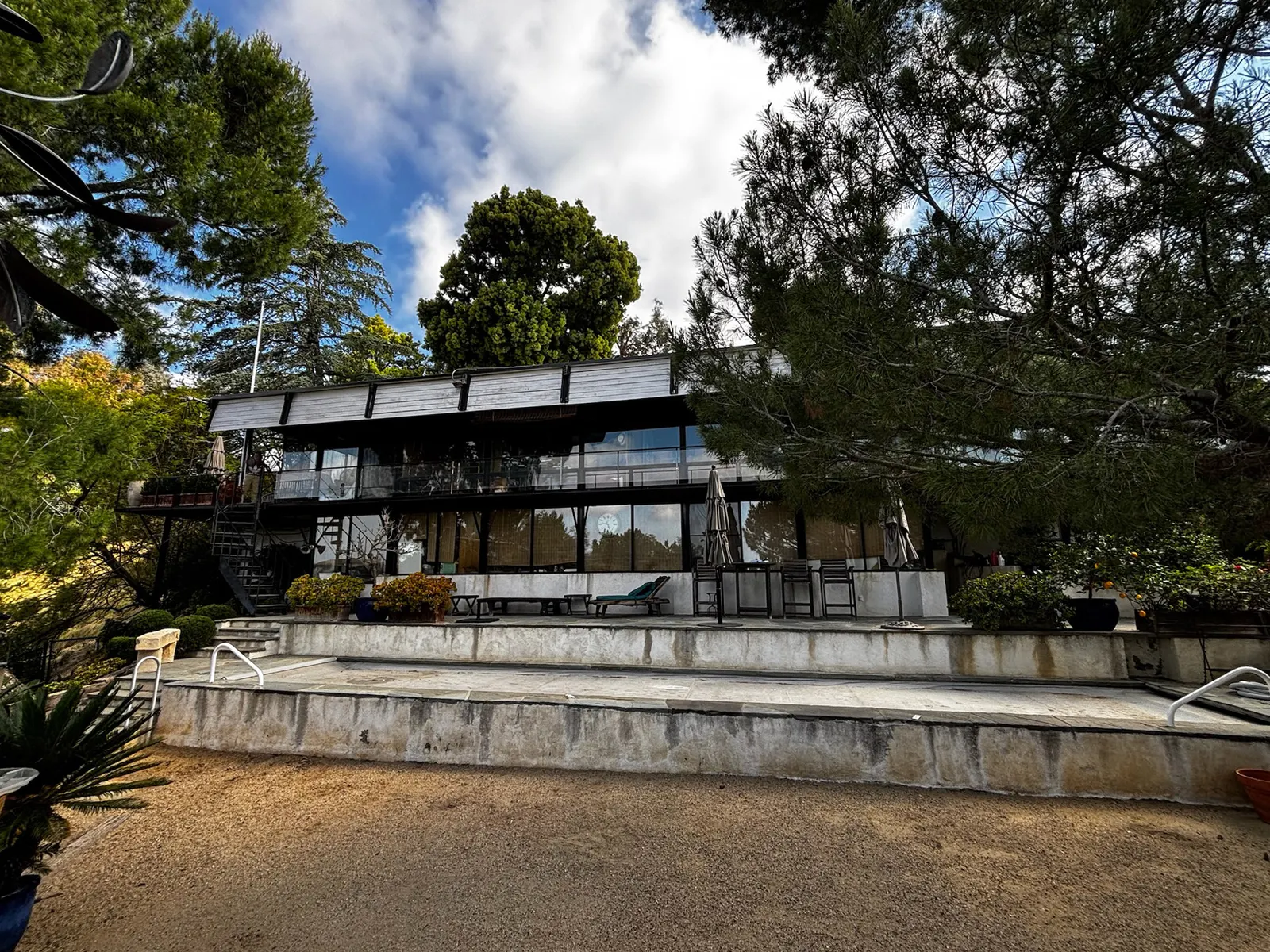 A modern glass hillside home with a pool and patio in the Westside hills