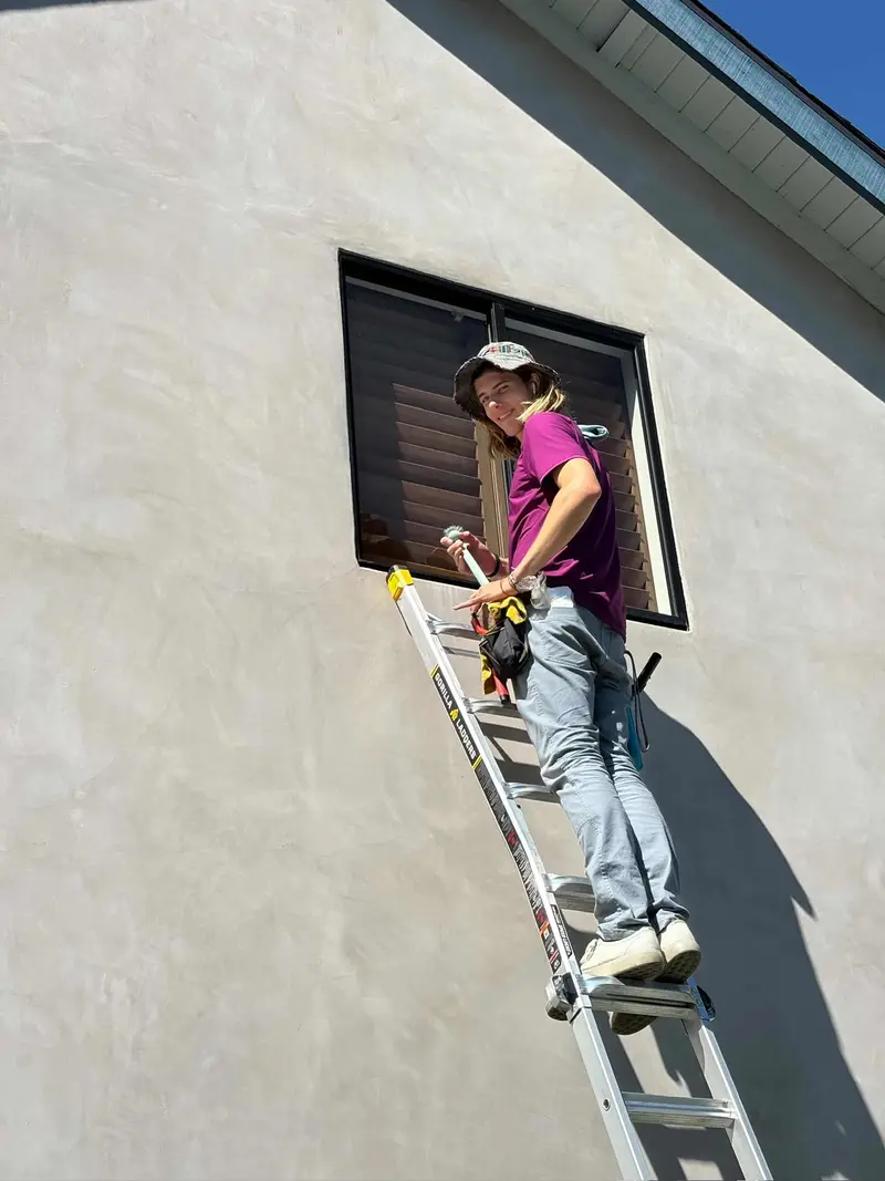 Gal of Happy Gator cleaning an upstairs window
