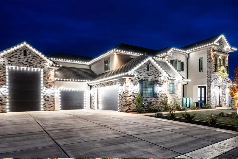 A large home fully outlined in Christmas lights at night