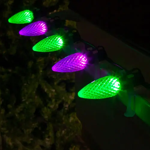 Purple and green bulbs alternating on a roofline