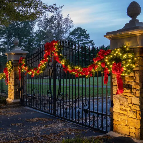 A lit wreath and garland on an estate gate